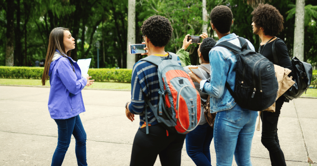 A college tour guide showing families around campus during an official visit